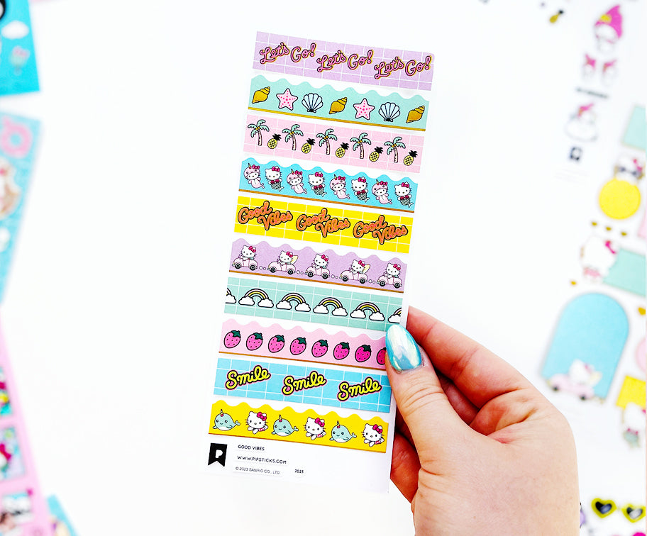 Hello Kitty and Friends Pipsticks sheets fanned out in a pink flatlay