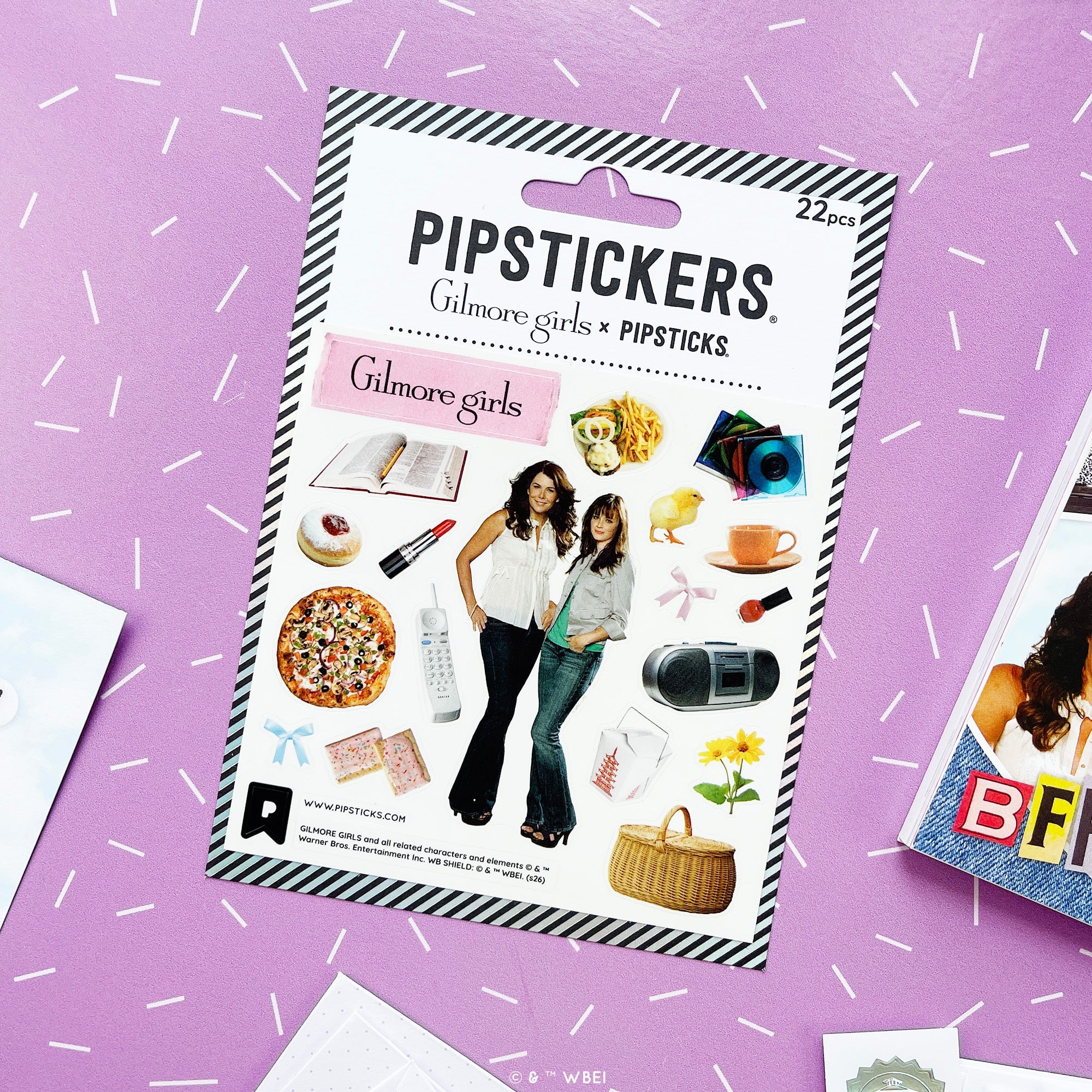 A package of PIPSTICKS 'Gilmore girls' stickers, containing 22 pieces. The packaging features a black and white striped border, the PIPSTICKS brand name, and a central white panel displaying various sticker designs inspired by the 'Gilmore Girls' series, including illustrations of characters and themed objects.