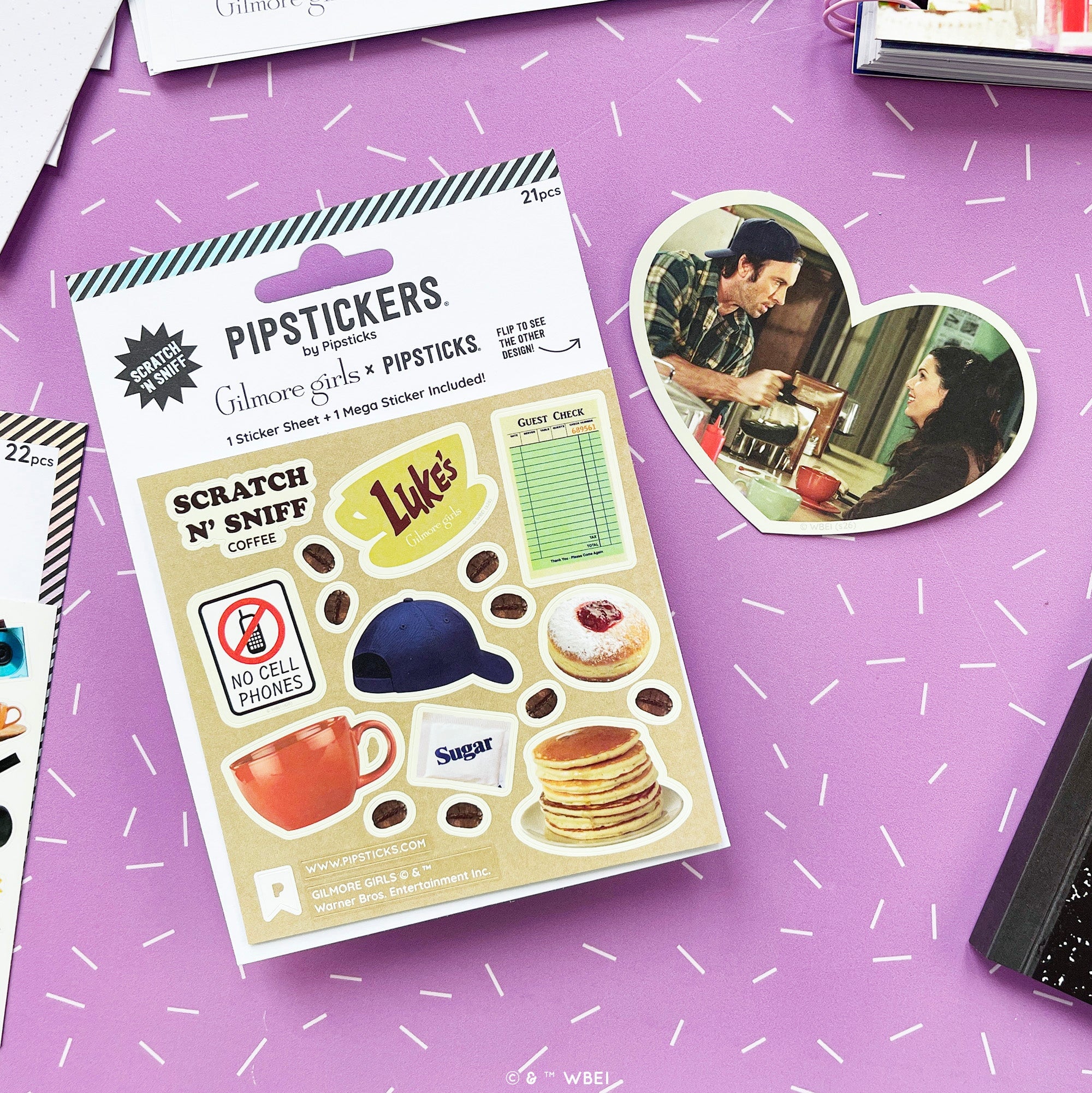 Photo shows coffee-themed sticker sheet with a heart-shaped inset showing characters from the movie in a cafe scene, on a white background. References Gilmore Girls, scratch and sniff